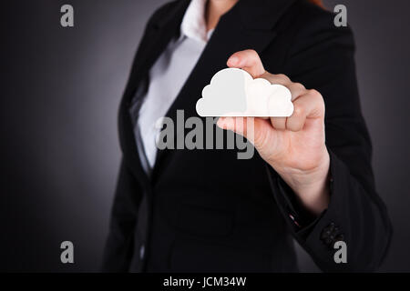 Portrait of businesswoman holding cloud computing icône sur fond noir Banque D'Images