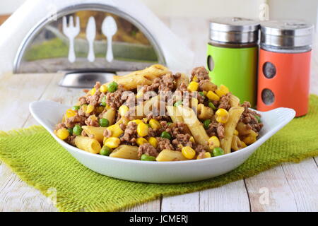 Des pâtes avec de la viande hachée, petits pois et le maïs jaune dans une assiette blanche. La cuisine maison. Concept de saine alimentation Banque D'Images