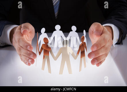 Portrait of businessman's hands la protection des personnes de l'équipe papier sur 24 Banque D'Images