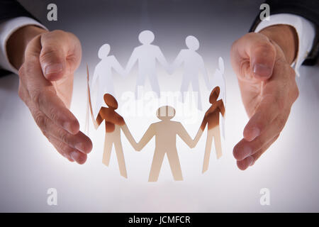 Portrait of businessman's hands la protection des personnes de l'équipe papier sur 24 Banque D'Images