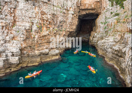 Vue depuis les falaises rocheuses de kayakistes explorer les eaux limpides de la Méditerranée d'une anse de la côte de Dubrovnik, Croatie Banque D'Images