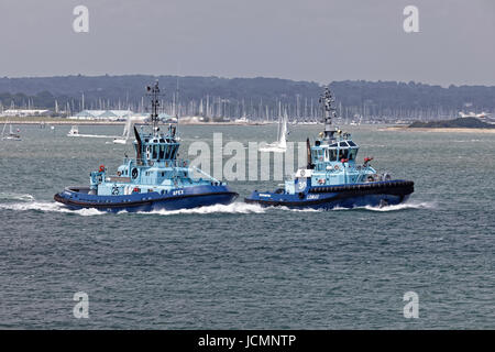 La flotte de remorqueurs Remorquage Solent et Apex Lomax 'steam' dans Southampton Water pour escorter un navire-citerne dans la raffinerie Esso Banque D'Images