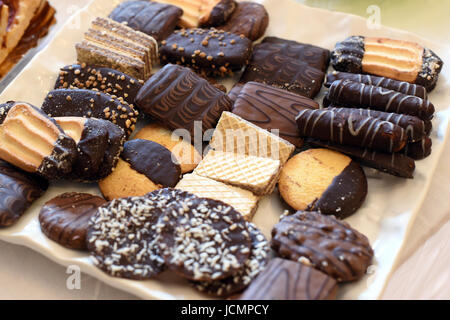 Plateau avec un assortiment de pâtisseries et de bonbons de chocolat frais sur une table buffet prêt à être servi en dessert ou avec une boisson chaude Banque D'Images