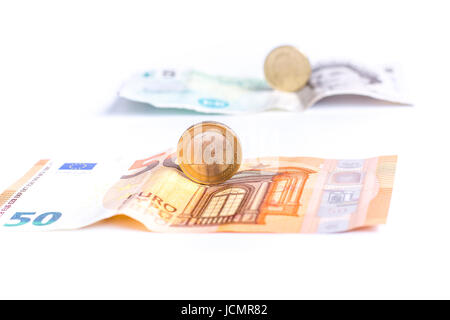 Billets et pièces en face de la livre sterling et des billets en euros isolé sur fond blanc Banque D'Images