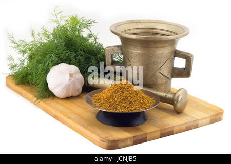 La vie toujours Les épices, pour seasonning,pilaf marigold staminas dans un vase de cuivre sur une planche en bois sur un arrière-plan d'un stupa stern pour broyer les épices, bun Banque D'Images