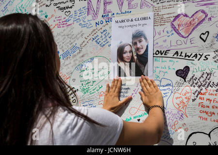 Londres, Royaume-Uni. 16 Juin, 2017. Une jeune femme met un poster d'amis disparus. Le Notting Hill Community pleure les victimes et vient ensemble pour aider ceux qui ont tout perdu après l'incendie de la tour de Grenfell, mercredi. Credit : Bettina Strenske/Alamy Live News Banque D'Images