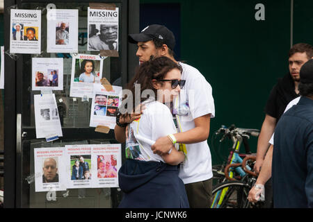 Londres, Royaume-Uni. 16 Juin, 2017. Un homme et une femme portant une personne manquante t-shirts réconforter mutuellement à l'extérieur de Latimer Road station de métro. Credit : Mark Kerrison/Alamy Live News Banque D'Images