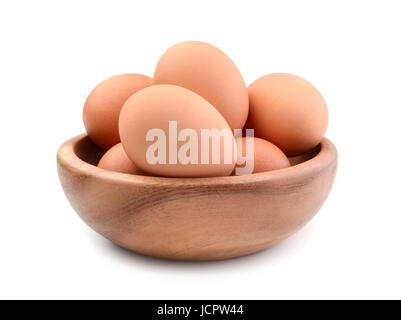 Les oeufs de poule dans un bol en bois isolé sur blanc Banque D'Images