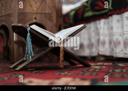 Coran livre saint des musulmans, un livre ouvert sur un stand avec rosaire Banque D'Images