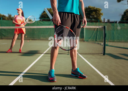 L'homme et de la femme joue au tennis sur l'air libre. Jeu de sport de la saison estivale. Mode de vie actif Banque D'Images