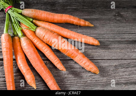 Les carottes orange fraîchement récolté sur une table en bois rustique Banque D'Images