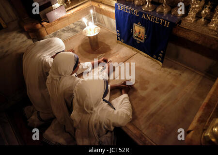 Religieuses catholiques romaines appartenant aux Missionnaires de la Charité de mère Teresa à Calcutta, Priant à l'intérieur de l'Aedicula rénovée la 14ème Station de la croix traditionnellement considérée comme le site de la crucifixion et la tombe de Jésus-Christ à l'intérieur de l'Église du Saint-Sépulcre dans le quartier chrétien vieille ville Jérusalem-est Israël Banque D'Images