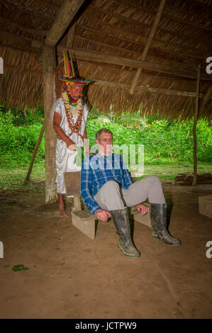 LAGO AGRIO, EQUATEUR - 17 NOVEMBRE 2016 : Siona shaman en costume traditionnel avec un chapeau de plumes dans un village indigène dans la réserve faunique de Cuyabeno Banque D'Images