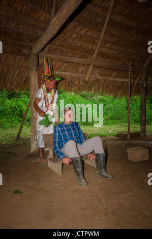 LAGO AGRIO, EQUATEUR - 17 NOVEMBRE 2016 : Siona shaman en costume traditionnel avec un chapeau de plumes dans un village indigène dans la réserve faunique de Cuyabeno Banque D'Images