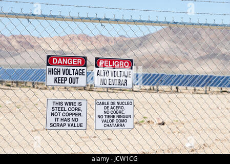 'Une haute tension/empêcher l' signes sur la clôture de l'énergie solaire Luning, un centre d'énergie solaire ferme près de Luning, Nevada. Banque D'Images