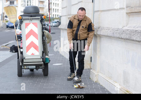 L'homme de travail debout près de poubelle sur street Banque D'Images