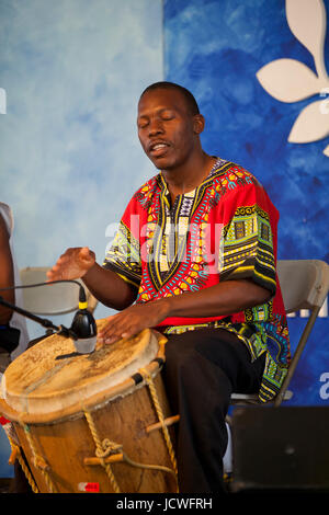 Homme africain jouant du tambour africain traditionnel sur la scène - USA Banque D'Images