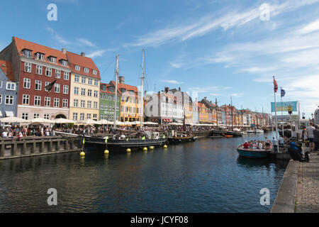 La foule la foule à bord de Nyhavn, Copenhague par un beau jour d'été. Les bateaux sont amarrés sur le canal et les touristes sont à bord d'un bateau pour un voyage Banque D'Images