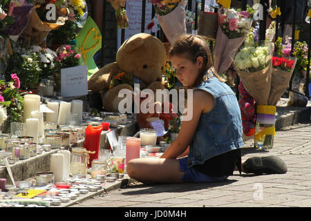 Londres, Royaume-Uni. 16 Juin, 2017. Une jeune fille est vu assis par l'extérieur du mémorial de Grenfell, Notting Hill Methodist Church dans le quartier de Kensington et Chelsea. Au moins 30 personnes ont bene morts confirmés avec environ 70 morts et disparus. Crédit : David Mbiyu/Alamy Live News ​ Banque D'Images