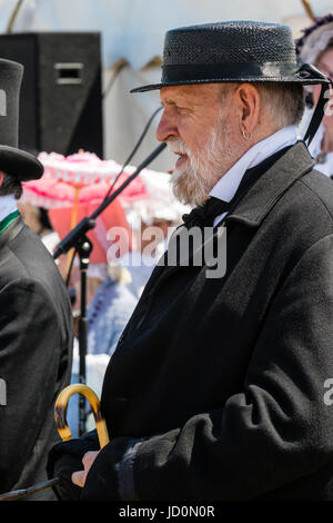 Portrait, side view, senior man outdoors habillés en costume victorien. Portant costume sombre et chapeau, avec barbe grise et à la très grave. Banque D'Images