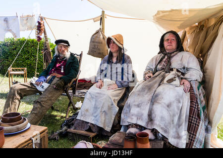 L'Angleterre, Broadstairs. Dickens semaine du festival. Marine, et sa femme, avec une autre femme, tous assis dans la rangée sous la tente. 'Voix de Londres victorien' les joueurs de l'histoire vivante, dans leur "chambre". Banque D'Images