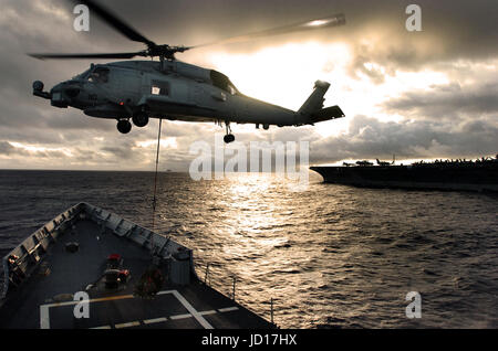 Un hélicoptère SH-60 Seahawk ramasse la cargaison de l'envol de l'USS Ford (FFG 54) au cours d'une opération de ravitaillement vertical avec le porte-avions USS JOHN C. STENNIS (CVN 74). DoD photo de Maître de 2e classe Oscar Espinoza, Marine américaine. Banque D'Images