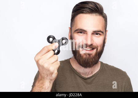 Young man holding et jouer avec fidget spinner. studio shot sur fond blanc. Banque D'Images