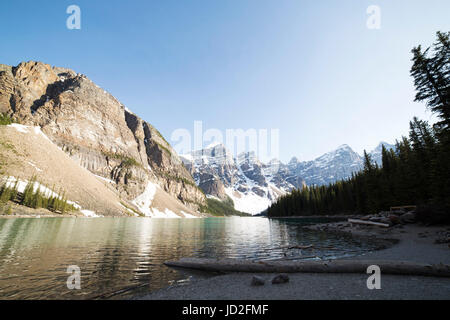 Le lac Moraine dans les Rocheuses canadiennes au parc national Banff en Alberta, Canada. Un journal est situé sur la rive du lac. Banque D'Images