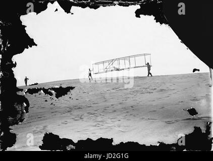 Début d'un Glide ; Wilbur en mouvement à la gauche tenant une extrémité du planeur (reconstruit avec gouvernail vertical unique), Orville allongé dans la machine, et Dan Tate à droite, photographié le 10 octobre 1902, Kitty Hawk, Caroline du Nord. La photographie a été faite sur un 5' x 7' et la plaque de verre sec est attribuée à Wilbur et/ou d'Orville Wright. Banque D'Images