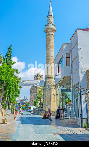 ANTALYA, TURQUIE - 6 mai 2017 : Le grand minaret en pierre de Tekeli Mehmet Pasa Mosque et la Tour de l'horloge sur l'arrière-plan, le 6 mai à Antalya. Banque D'Images