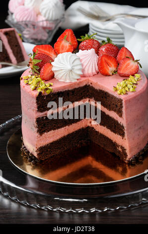 Chocolat Fraise gâteau décoré avec des baies, de la meringue et les pistaches dans une coupe Banque D'Images