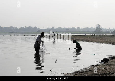 U-Bein Bridge/Amarapura - Myanmar 22 Janvier 2016 : Deux pêcheurs sur le lac Taungthaman leur contrôle sont prises pour net. Banque D'Images