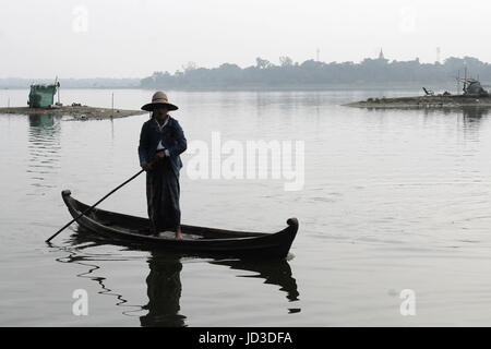 U-Bein Bridge/Amarapura - Myanmar 22 Janvier 2016 : une femme est manovering son bateau sur le make qui est traversé par le célèbre pont u-bein. Banque D'Images