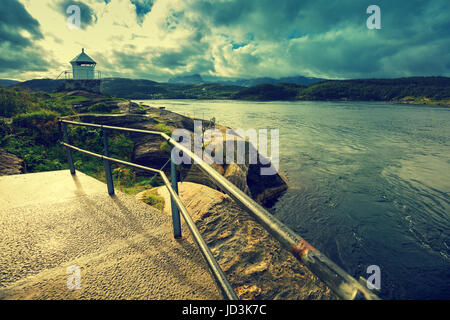 Leuchtturm contre une ciel nuageux pendant le coucher du soleil Banque D'Images