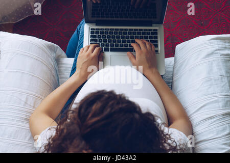 Pregnant woman holding laptop dans ses mains, vue du dessus Banque D'Images