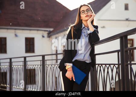 Les jeunes à la businesswoman with notebook posing in the city Banque D'Images