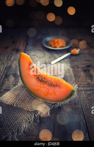 Tranche de melon sur table rustique en bois aces Banque D'Images