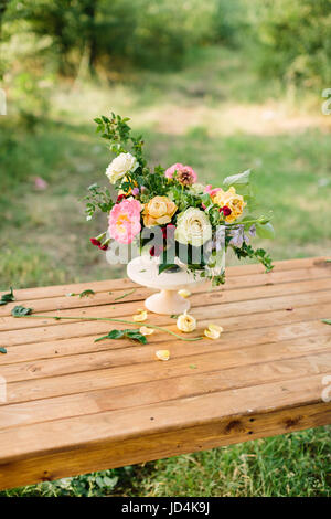 Design floral, mariage, romance concept - superbe bouquet composé de roses, d'avalanches, de pivoines et d'dianthuses, décoré de feuilles de chêne et de framboise-bush, debout dans un vase sur la table en bois Banque D'Images