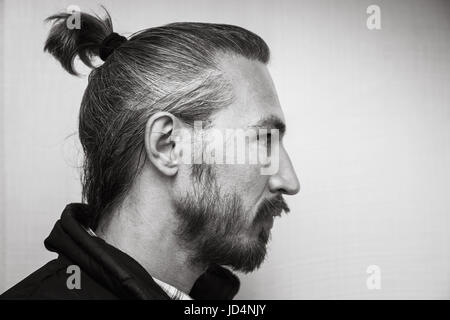 Profil profil noir et blanc portrait de jeune homme au-dessus de l'Asie barbus light grey wall background Banque D'Images