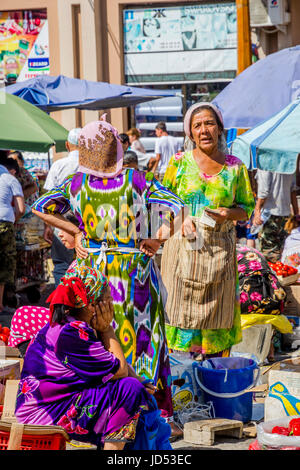 SAMARKAND, OUZBÉKISTAN - 28 août : deux femmes habillées en vêtements traditionnels de l'Ouzbek et parler de l'argent comptant à Siab bazar, marché local à Samarkand Banque D'Images