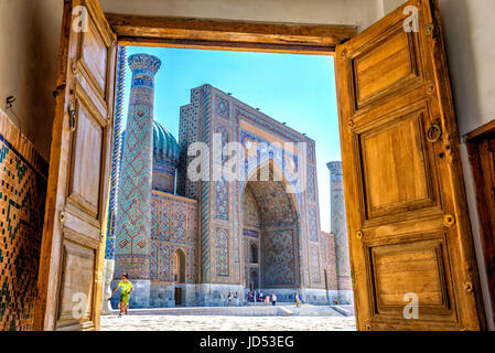 SAMARKAND, OUZBÉKISTAN - 28 août : Vue de Sher Dor Madrasah thru la porte en bois sculpté du Reghistan - monument de Samarkand. Photo HDR. Août 2016 Banque D'Images