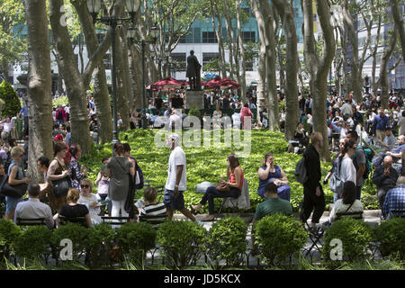 Bryant Park à Manhattan, sur une chaude journée de printemps est toujours rempli de touristes et les employés de bureau à l'heure du déjeuner à proximité d'immeubles de bureaux. Banque D'Images