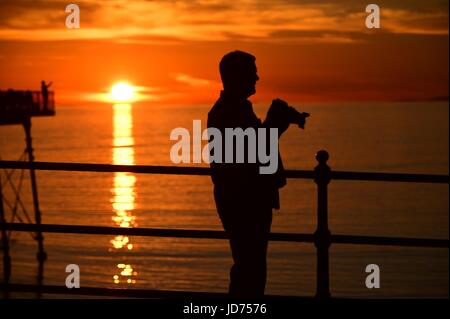 Pays de Galles Aberystwyth UK, dimanche 18 juin 2017 UK weather : les personnes bénéficiant de l'amende chaude soirée au coucher du soleil sur la baie de Cardigan à Aberystwyth, sur la côte de l'ouest du pays de Galles après une journée de soleil chaud Photo © Keith Morris / Alamy Live News Banque D'Images