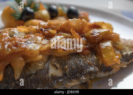 Le poisson cuit au four, accompagné de pommes de terre à l'or et les olives dans un plat blanc. Plat typiquement portugaise. Banque D'Images