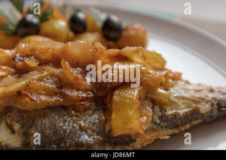 Le poisson cuit au four, accompagné de pommes de terre à l'or et les olives dans un plat blanc. Plat typiquement portugaise. Banque D'Images