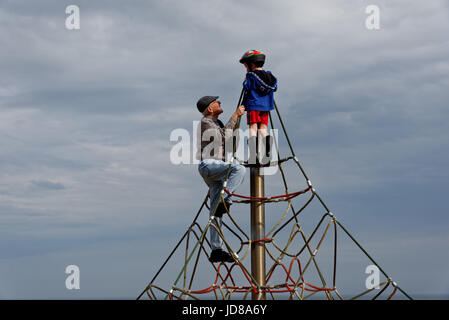 Un grand-père remonte jusqu'en haut d'un mur d'escalade avec son petit-fils (5 ans) Banque D'Images