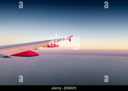 Pointe rouge et blanc de l'aile d'avion dans le ciel à l'horizon." Banque D'Images