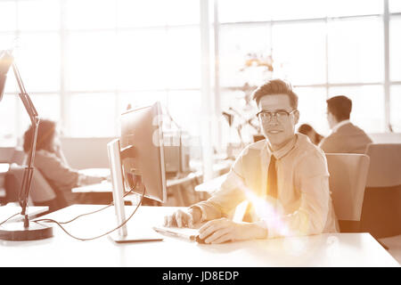 Young businessman programmeur dans big bright office au travail à l'aide d'ordinateur Banque D'Images