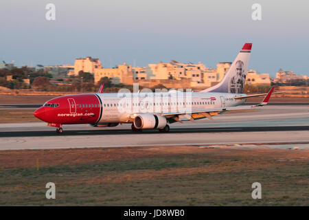 Transport aérien moderne. Norwegian Airlines Boeing 737-800 passenger jet avion avec Internet sans fil à bord d' atterrissage titres à Malte au coucher du soleil Banque D'Images