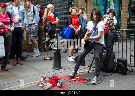 Un musicien musicien ambulant qui joue de la guitare dans Brick Lane, East London, UK Banque D'Images